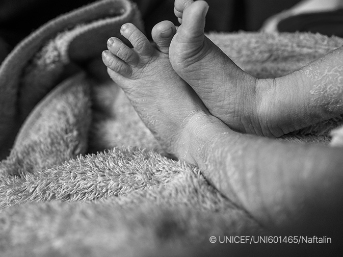 수건 위에 누워 있는 신생아의 발 이미지