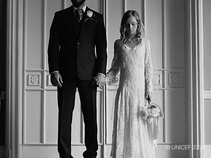 정장 차림의 남성과 흰 드레스를 입은 어린 소녀가 손을 잡고 서 있는 모습 이미지