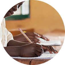 종이에 펜으로 글을 쓰고 있는 어린이의 손 이미지